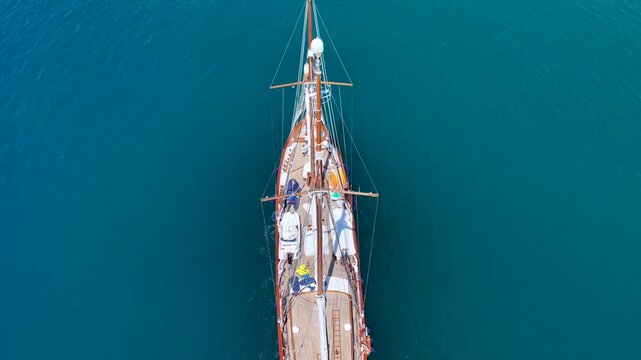 Aerial drone cinematic video of classic sailing wooden ship cruising in low speed near marina and port of Zea or Pasalimani, Piraeus, Attica, Greece