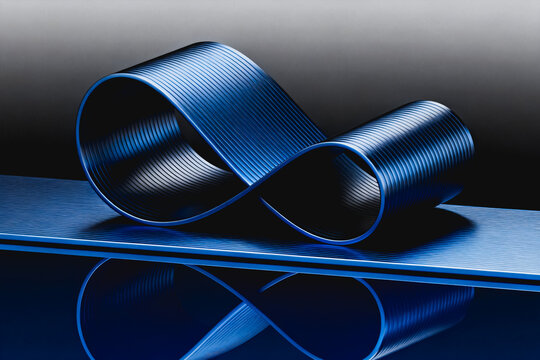 A polished blue metallic mobius strip placed on a reflective blue surface, with soft studio lighting highlighting its textured curved surface and subtle shadows.