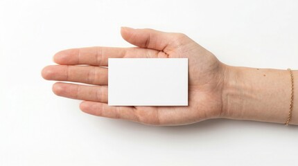 Obraz premium Blank white business card held in an open palm, a clean minimalist template for branding and contact information, ideal for corporate identity and networking.