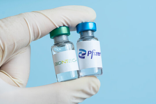 Vials of liquid the logos pfizer and biontech in the hand.