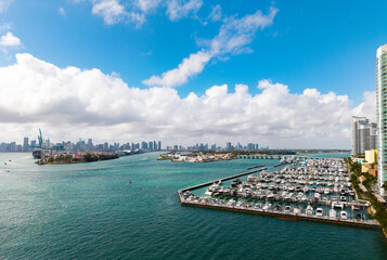Obraz premium Yacht docked at Miami marina. Aerial view of coastline in Miami. Sailboat cruising along the Miamis shore. Miami skyline above harbor. Famous Miami Beach marine from above. Marina with yachts.