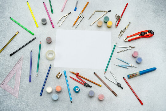 Creative workspace with blank white paper, various supplies back to school background. Draw brushes, pencils drawing compasses stationery tools flat lay copy space