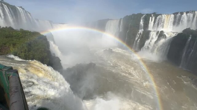 Camera pans from waterfall edge to massive cascade from boardwalk footage