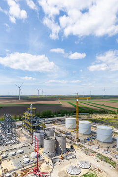 Construction of a modern agricultural grain terminal with wind turbines on the horizon