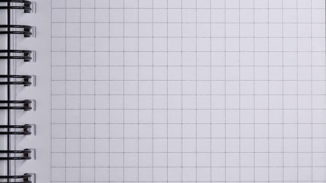 The sheets of a squared notebook are turned over