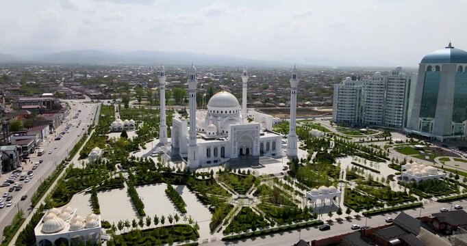 Cinematic aerial orbit shot of the main white dome with golden crescent of the Pride of Muslims mosque in Shali, Chechnya