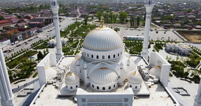 Cinematic aerial drone boom down shot approaching the main white dome of the Pride of Muslims mosque in Shali, Chechnya