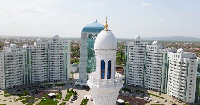 Cinematic aerial orbit shot of the white marble minaret tower detailing geometric patterns at the Pride of Muslims mosque in Shali, Chechnya