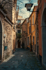 Fototapeta premium Narrow Alleyway with Old Stone Walls and Historic Buildings in Taormina