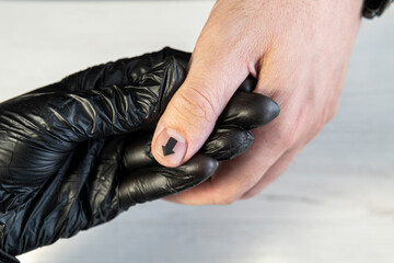 Fototapeta premium Man manicure. The process of coloring nails on men's fingers in a beauty salon. Manicurist girl gives a guy a manicure