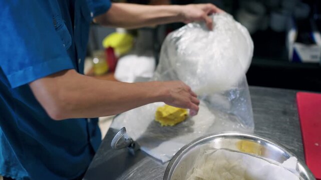 Professional male chef in a commercial kitchen preparing fried green plantains, a typical dish from Costa Rica known as patacones