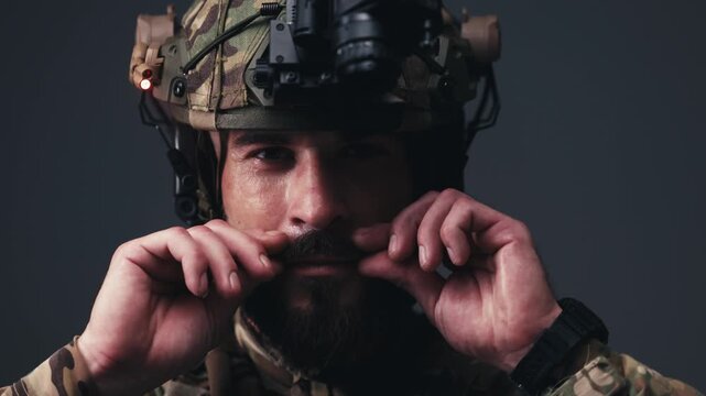 Confident soldier in tactical helmet smiling at camera, showcasing military gear and determined expression. Concept defense, security and professional service.
