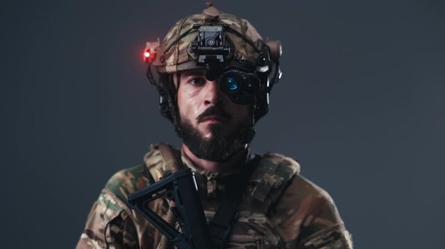 Soldier in tactical gear with helmet and night vision device stands confidently, showcasing military readiness and focus against a neutral background