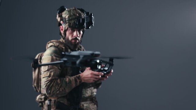 Tactical soldier in camouflage uniform operates drone with remote controller, focused on flight path, equipped with head-mounted display in a controlled indoor environment
