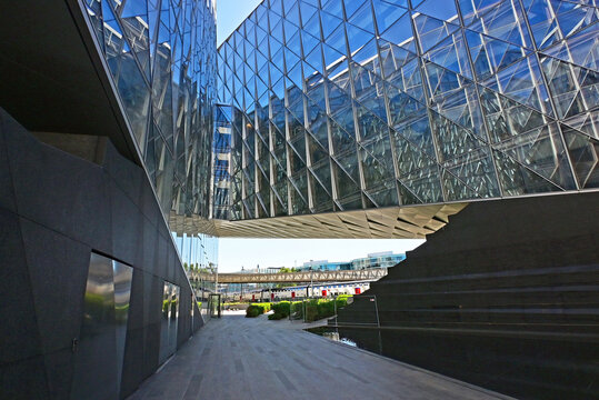 Geneva, Switzerland, Europe :  05.08.2026 : Japan International Tobacco headquarters building, Stadler trains in Geneve-Secheron station, pedestrian passage leading to Maison de la Paix, Graduate Inst