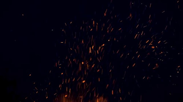 Cinematic fire flames with glowing embers and flying sparks rising against a deep black background, perfect for intense overlays and dynamic visual effects.