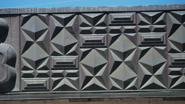 Close up view of a decorative geometric facade featuring repeating three dimensional patterns and architectural textures