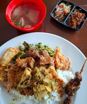 Indonesian food called nasi babi guling with rice, satay pork and sambal.