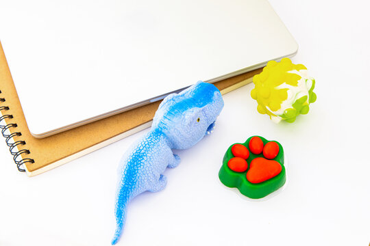 Office stress management tools include stress relief toys and a laptop placed on a simple desk during working hours