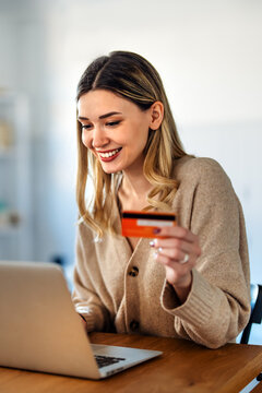 Woman managing finances through online banking with a credit card and laptop at home