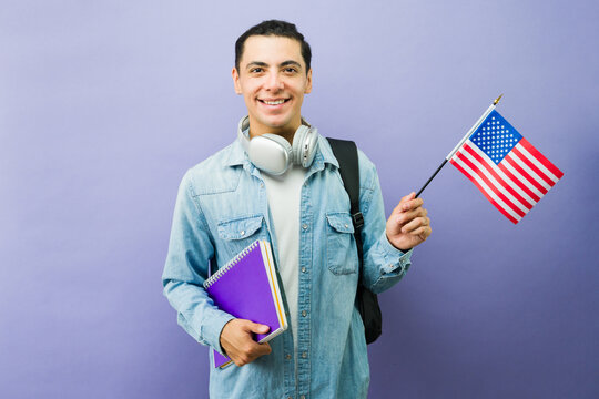 Happy male student holding usa flag and notebooks, studying abroad, ready for international education