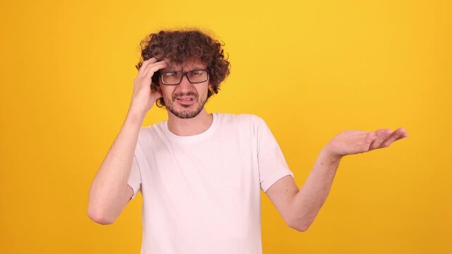 Person expressing confusion with raised hand and a puzzled gesture, showing clear bewilderment and expressive hand movement in a bright yellow studio portrait.