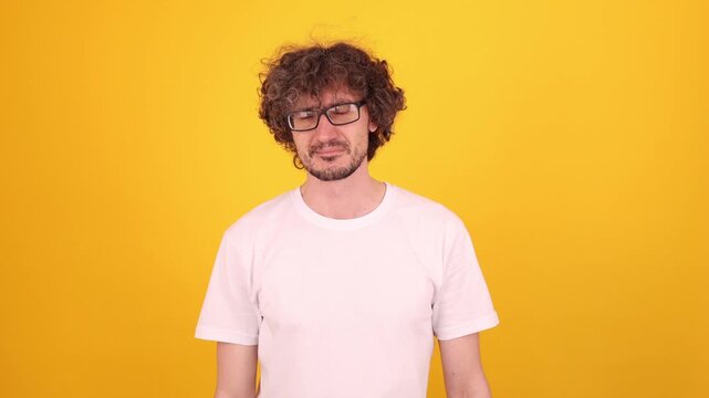 Young person looking directly at the camera with an open‑mouth shouting expression in a bright yellow studio portrait, conveying strong emotion, intensity and a scolding vibe.