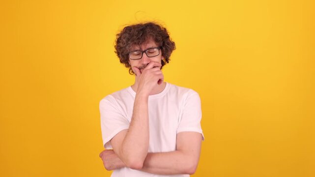 Person touching the chin in a thoughtful pose, looking upward with a subtle spark of insight, conveying a moment of realization against a bright yellow background.