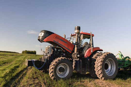 Agricultural tractor with open hood in field, tractor repair after breakdown, engine maintenance and farm machinery service, machine downtime during seeding work, farming and rural field 