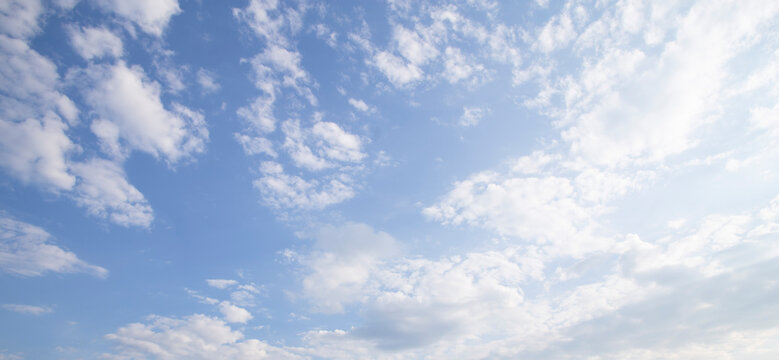 Blue Sky Background with Soft White Clouds and Bright Sunlight