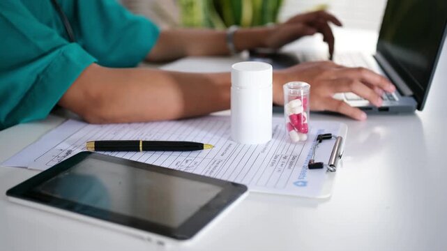 A doctor writes a prescription for a patient. A doctor writes a health note and a patient's medical record on his laptop. A close-up of a medicine bottle with a doctor typing on his laptop in the back