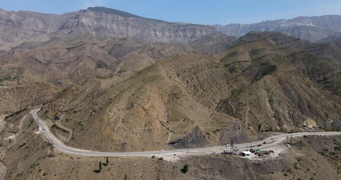 Cinematic aerial tracking shot along a winding mountain highway and viewpoint road serpentine in Dagestan