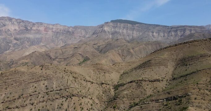 Cinematic aerial view of dramatic layered mountain ridges and texturized hills in Dagestan
