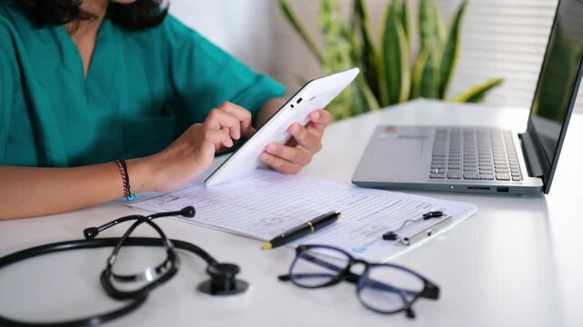 Doctors scroll and type on smartphones in hospitals for research, communication, or healthcare news. They use smartphones and type in clinics for electronic medical records and mobile health apps.