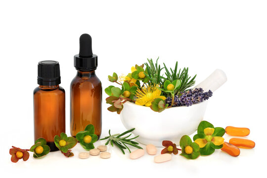 Natural supplements and herbs to treat depression, brown tincture bottles, mortar, capsules, tablets, St Johns Wort, rosemary, lavender on white.