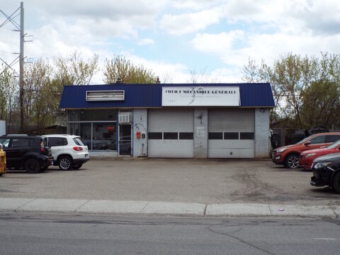Gatineau, Quebec, Canada &ndash; May 8, 2026: The "Th&eacute;o.T M&eacute;canique G&eacute;n&eacute;rale" auto shop features a blue roof, two garage bays, and vehicles in the lot at 341 Boul. Alexandre-Tach&eacute;.