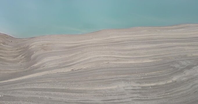 Cinematic aerial revealing shot flying forward over a rocky cliff to disclose Chirkey reservoir in Dagestan