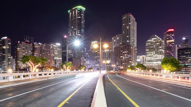Night time lapse of traffic going over a Brickell Key Bridge and the tall buildings of Miami Florida