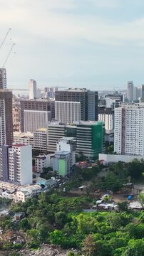 Aerial shot of the poor neighborhoods mixed in with new modern high-rises in Cebu City Philippines. Vertical Video.