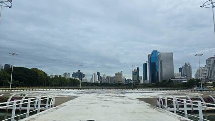 Naklejka premium Panoramic city skyline view from a waterfront park in Bangkok, Thailand.
