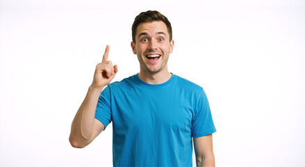 Naklejka premium Excited young man pointing finger up at copy space. Surprised caucasian male in blue t-shirt having an idea against white background. Concept of inspiration and solution