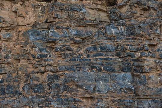 layers of various limestone rocks visible in the exposed mountainside