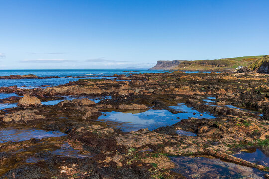The magnificent 200 metre high vertical Fair Head Cliff in Co Antrim, Northern Ireland with Scotland's Mull of Kintyre in the background.  One of the best rock climbing locations in The British Isles.