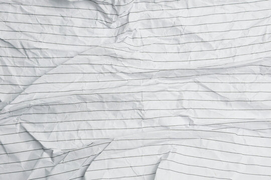 Crumpled white lined paper texture with natural folds and wrinkles. Ideal for graphic design, presentations, stationery mockups, creative projects, and textured backdrop concepts.