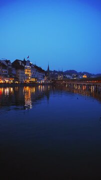 Vertical static shot of the historic Chapel Bridge and Reuss river at dusk