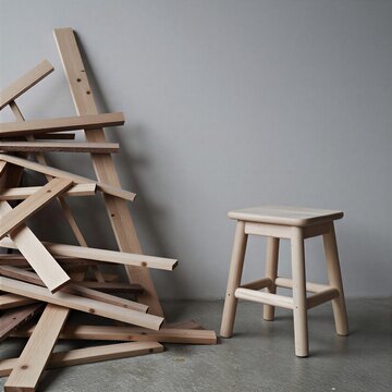 Minimalist wooden stool and scrap wood in a workshop