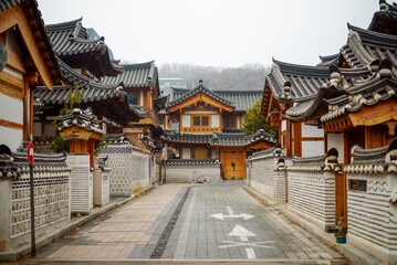 Fototapeta premium Traditional Korean hanok houses line a peaceful residential street in Eunpyeong Hanok Village, showcasing classic Korean architecture and cultural heritage in Seoul.