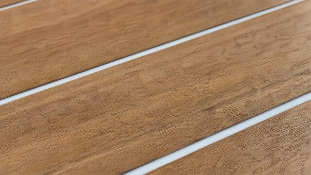 Wooden planks with gaps filled by a smooth white caulk line.