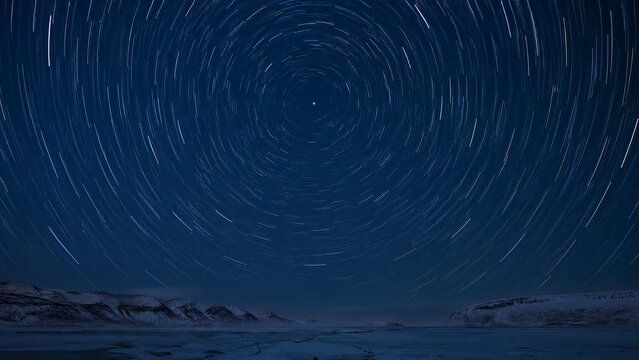 Arctic night sky with star trails circling a bright Polaris star in dark blue tones.