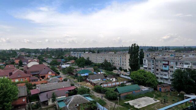Panoramic aerial view of residential area with houses and apartment buildings under cloudy sky